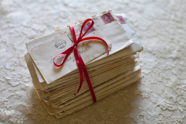 Stack of old letters tied in red ribbon